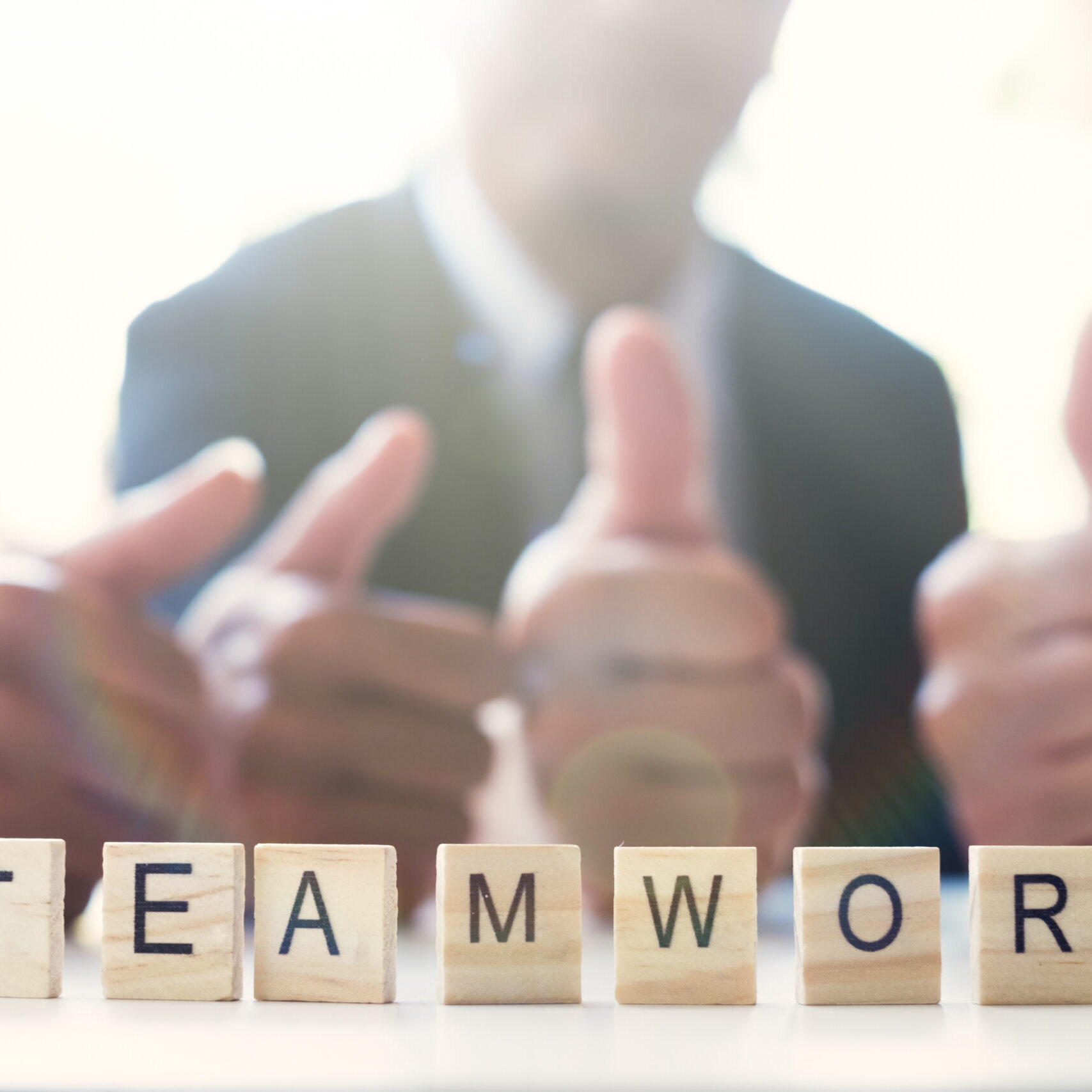 “Teamwork” word on business working table. Wooden cross word alphabet “Teamwork”. Business teamwork concept.